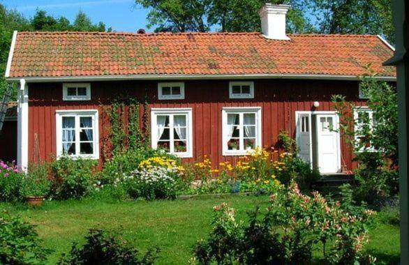 una casa roja con un jardín delante en Lillåns B&B, en Örebro