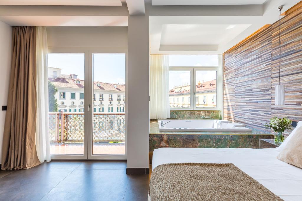 a bedroom with a tub and a large window at Dei Martiri Suite in Naples