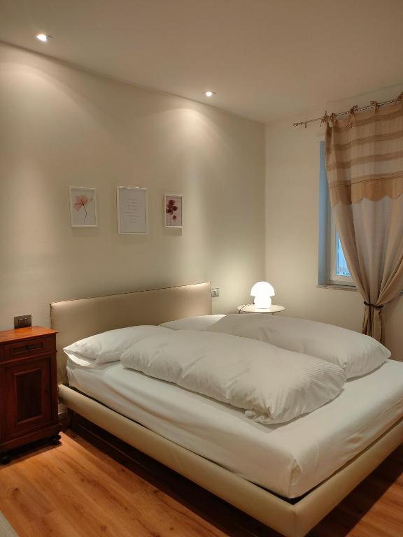 Hotel Mentana Suite, a bedroom with a white bed with a table and a window at Mentana Suite in Verona