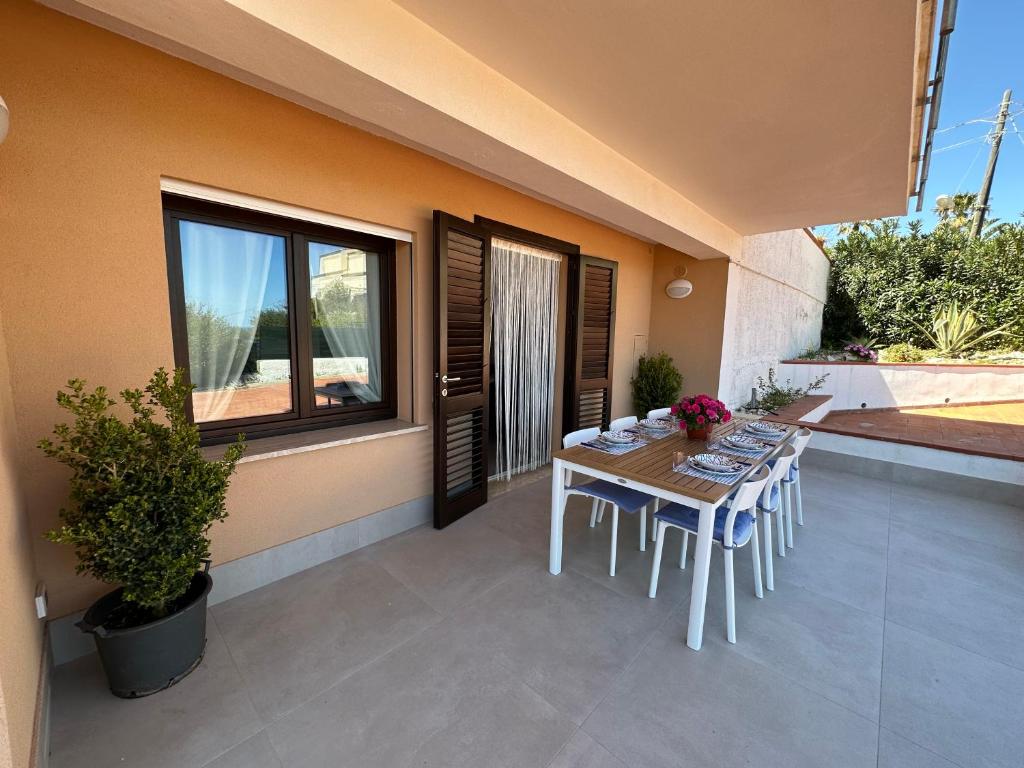een tafel en stoelen op de patio van een huis bij Villa FIORENZA - 100 mt dal Mare in Castellammare del Golfo