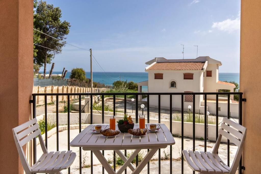 d'une table et de deux chaises sur un balcon donnant sur l'océan. dans l'établissement ~ Villa Demetra ~, à Noto Marina