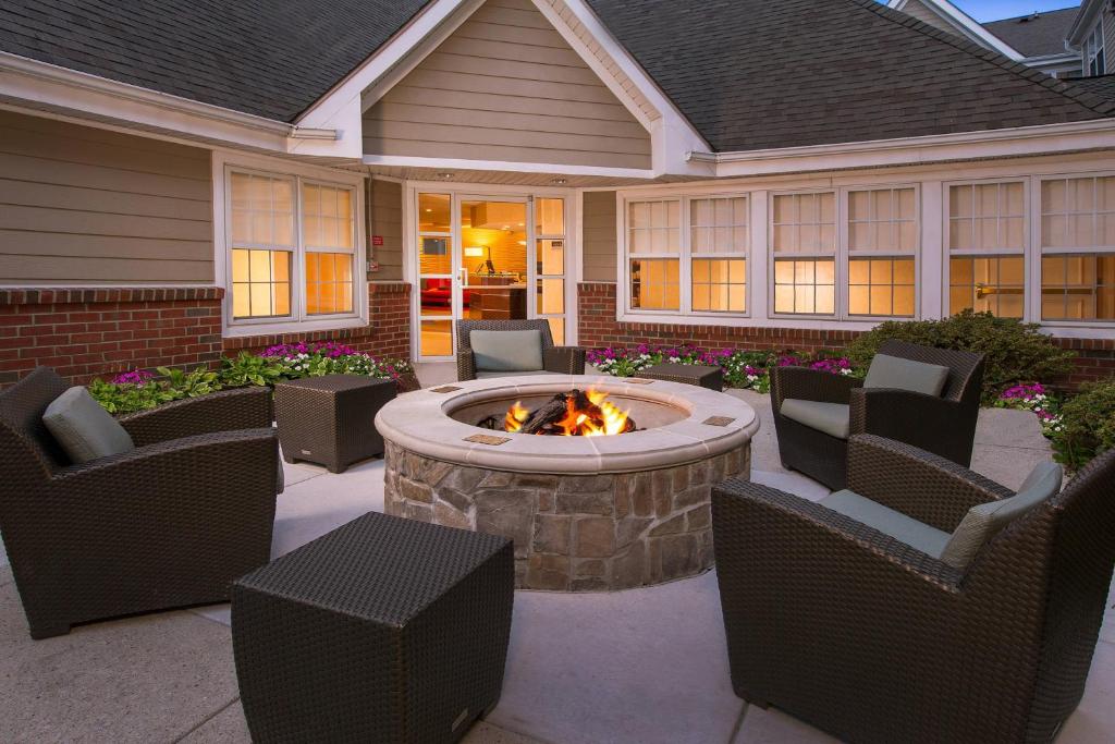 une terrasse avec des chaises et un foyer extérieur en face d'une maison dans l'établissement Residence Inn Columbia MD, à Ellicott City