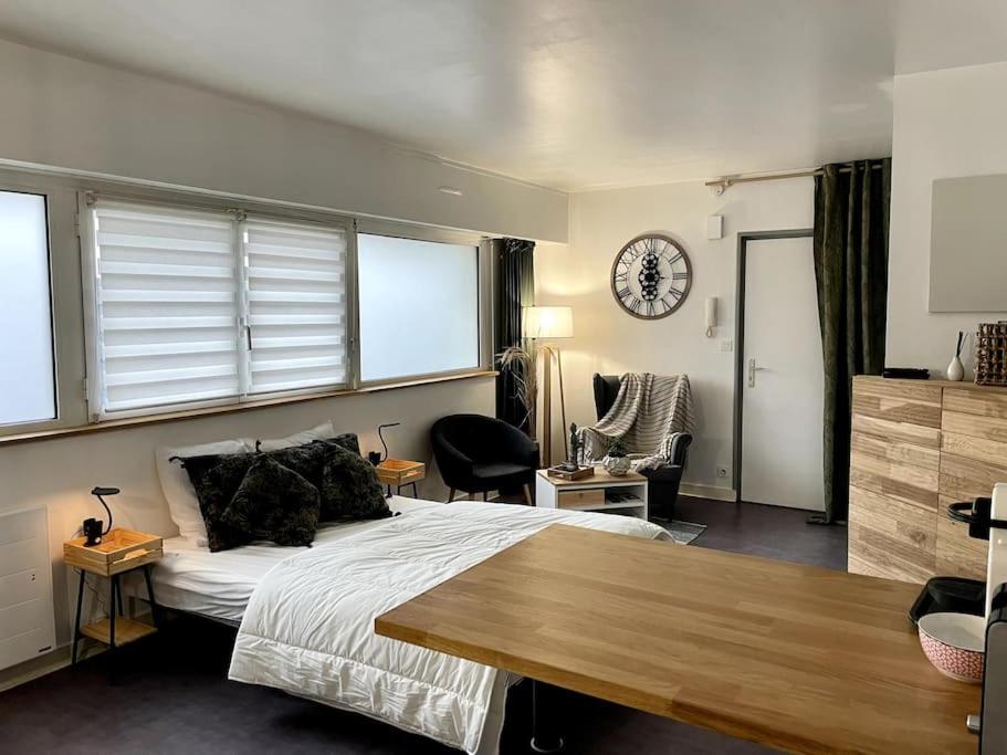 ein Schlafzimmer mit einem Bett und einer Uhr an der Wand in der Unterkunft Charmant Appartement Vannes Centre 30m2 in Vannes