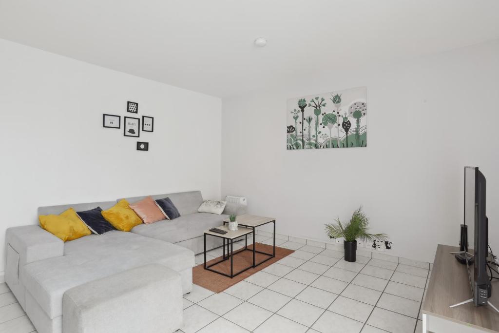 a white living room with a couch and a tv at Budget spacious apart with terrace in Mantes-la-Jolie