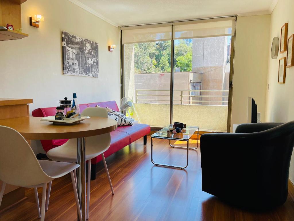 sala de estar con sofá rojo y mesa en Barrio Lastarria, Excelentes Apartamentos - Sofia Camilla Propiedades, en Santiago