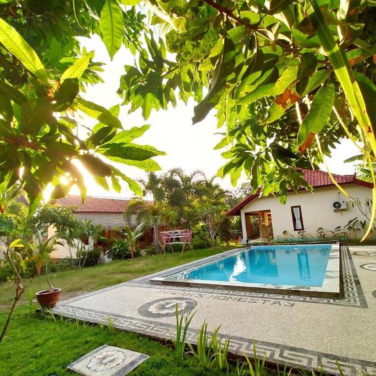 a swimming pool in the yard of a house at Serah's Homestay in Kuta Lombok