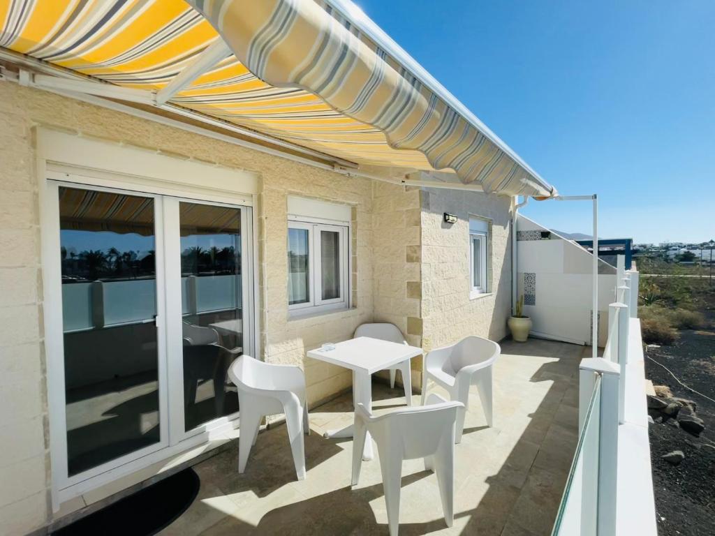 a patio with a table and chairs and an umbrella at La Terraza in Playa Blanca