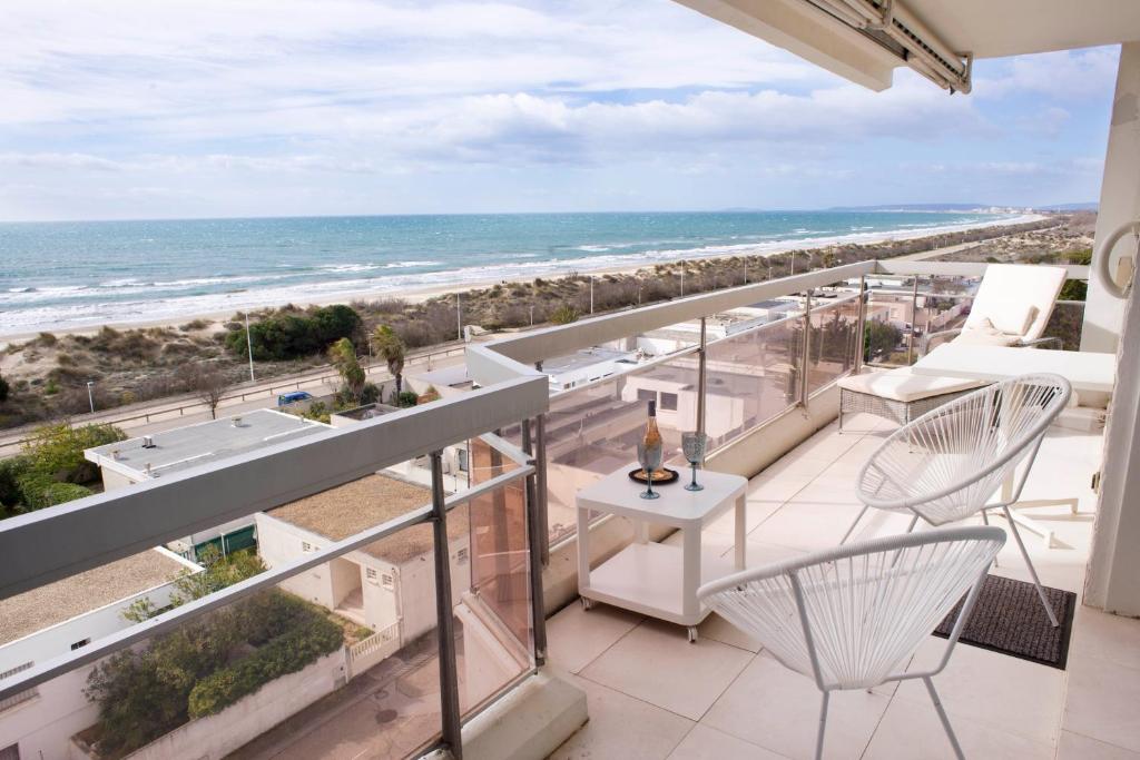 d'un balcon avec des chaises et une vue sur la plage. dans l'établissement * Le Rêve Bleu * Vue Mer *, à La Grande Motte