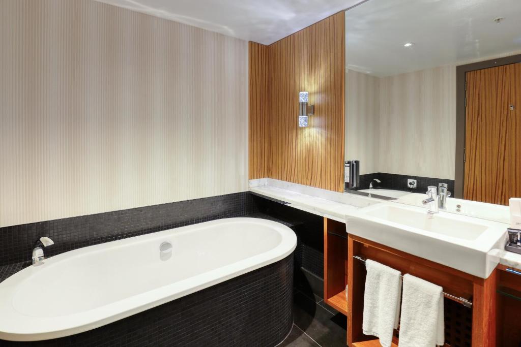 a bathroom with a large tub and two sinks at Marsden Viaduct in Auckland