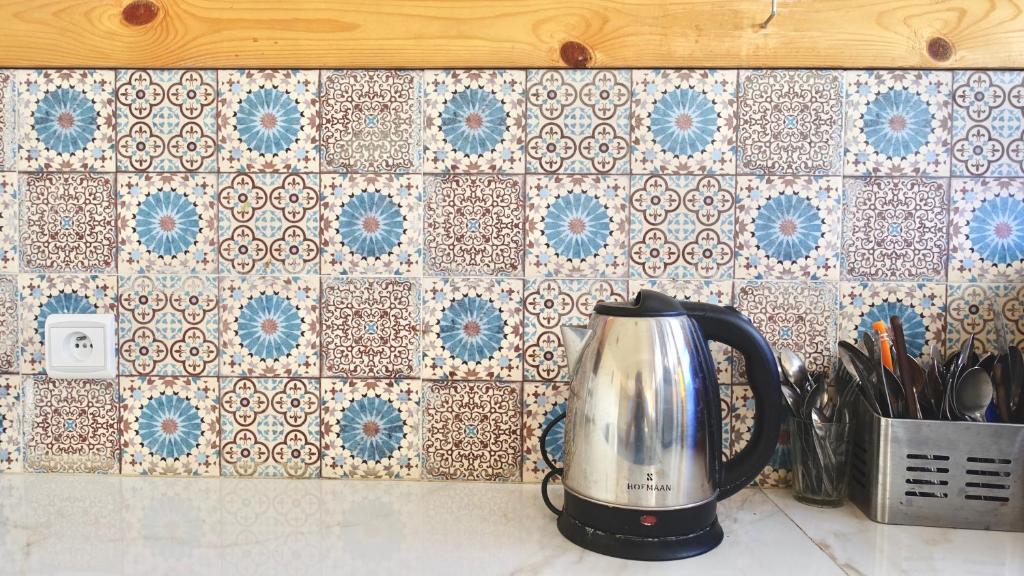 uma chaleira de chá num balcão com uma parede de azulejos em Cozy Surf House em Taghazout