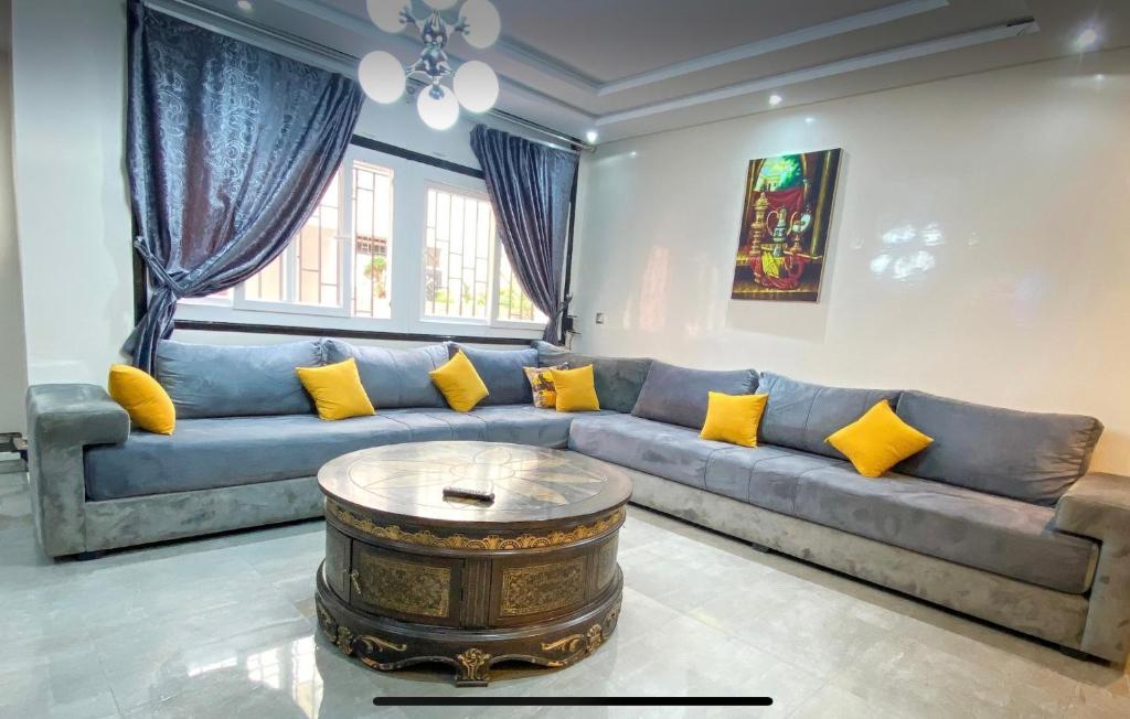 sala de estar con sofá azul y almohadas amarillas en Location de rêve à El Jadida, juste à côté de la plage, Vivez l'aventure en El Jadida