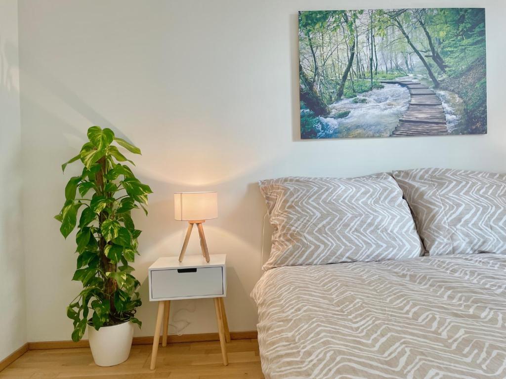 a bedroom with a bed with a plant and a picture at 55m2 Modern Flat with Balcony in Vienna