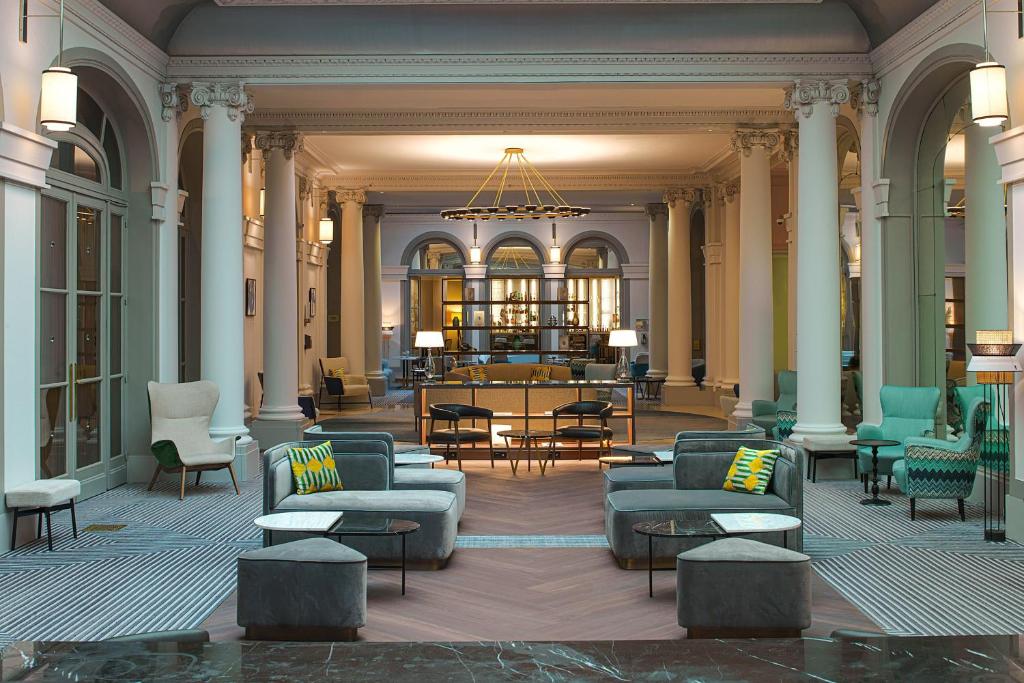 een lobby met banken en tafels in een gebouw bij Paris Marriott Opera Ambassador Hotel in Parijs