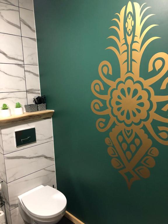 ein Badezimmer mit einem WC und einer grünen Wand in der Unterkunft Lux House Chochołów in Chochołów