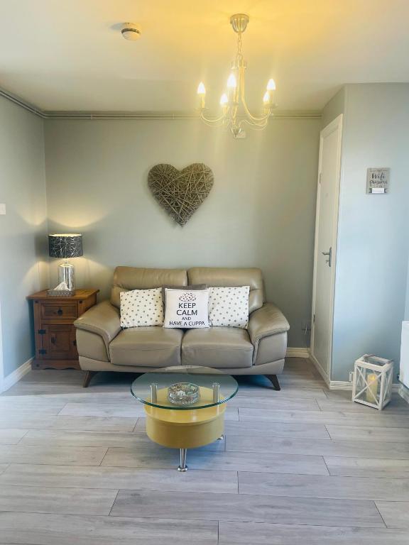 una sala de estar con sofá y un corazón en la pared en Malvern Apartment, en Derry Londonderry