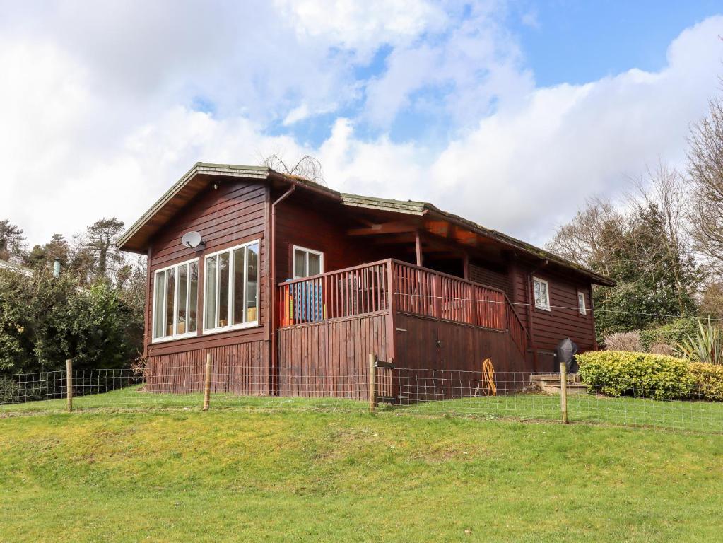 a small wooden house on a grassy field at Watersview Lodge in Leek