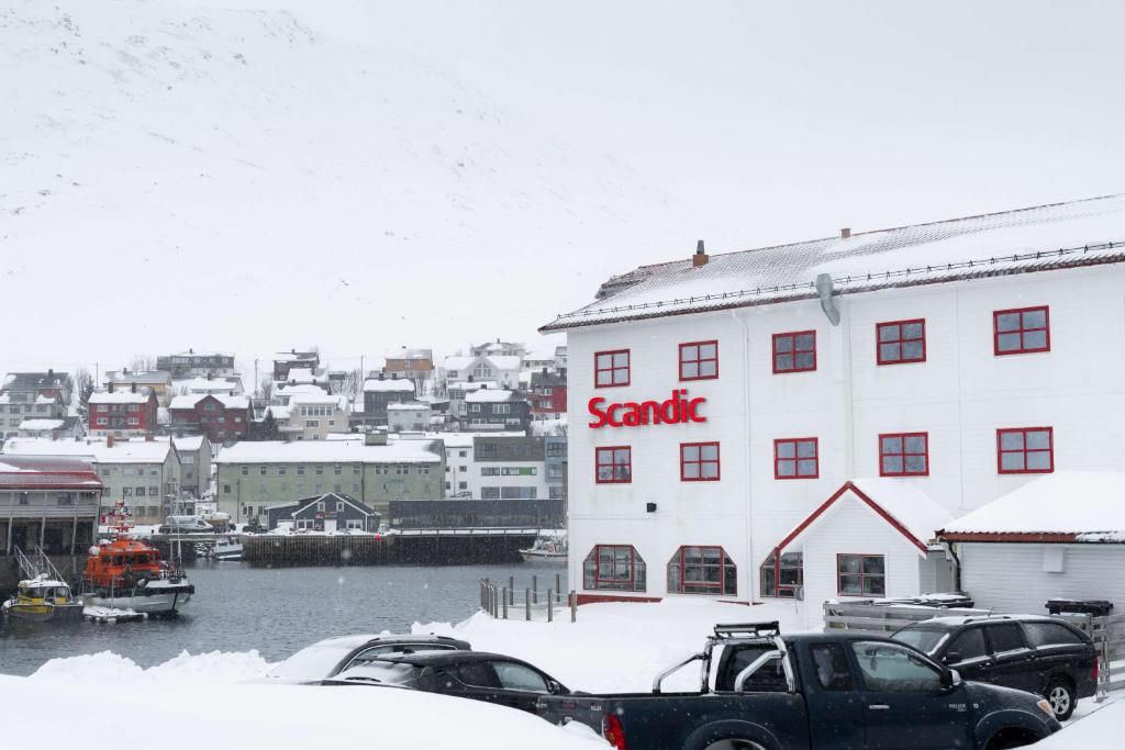 a large white building with a sank sign on it at Scandic Bryggen in Honningsvåg