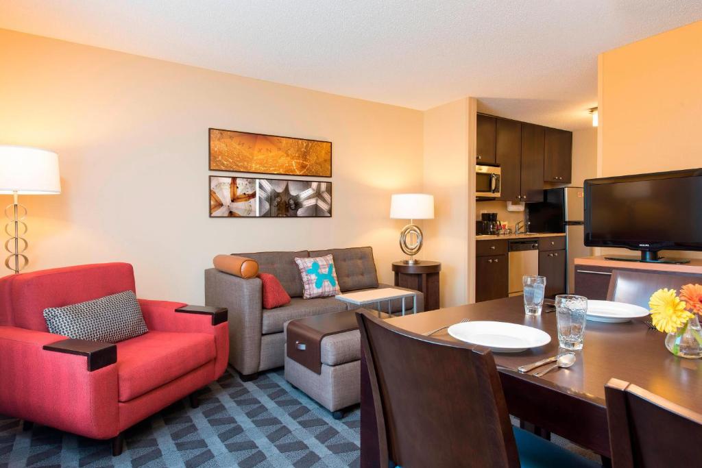 a living room with a dining table and a living room at TownePlace Suites by Marriott Kalamazoo in Portage