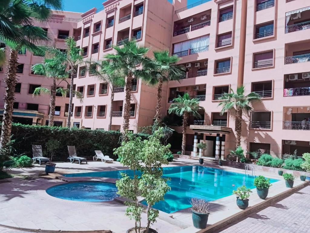 una piscina di fronte a un edificio di Apparts KARAMI a Marrakech