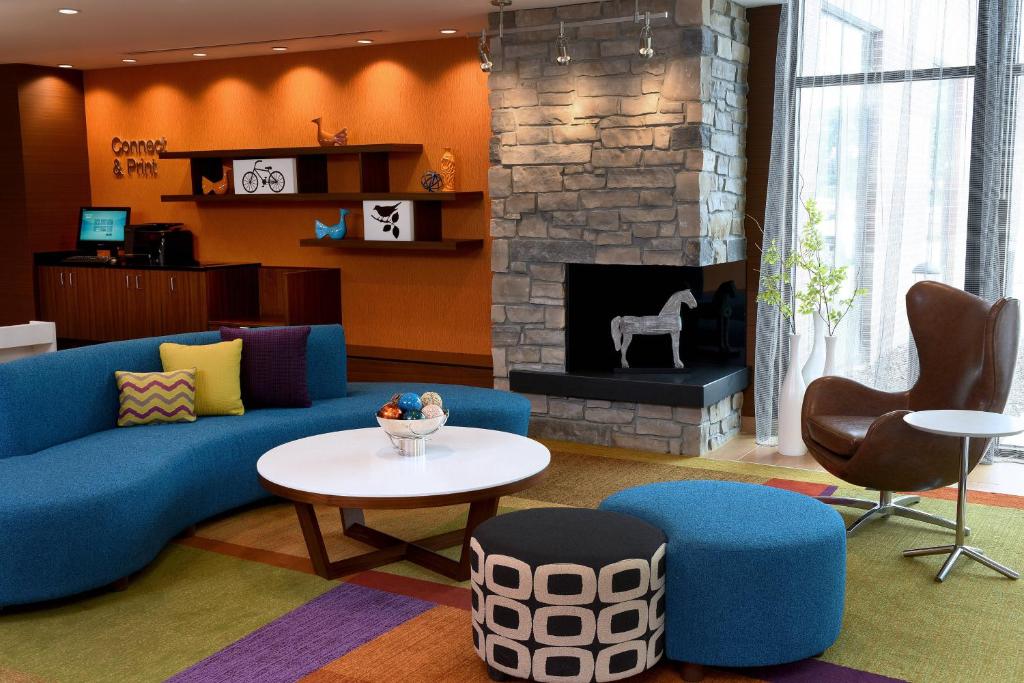 a living room with a blue couch and a fireplace at Fairfield Inn & Suites by Marriott Omaha West in Omaha