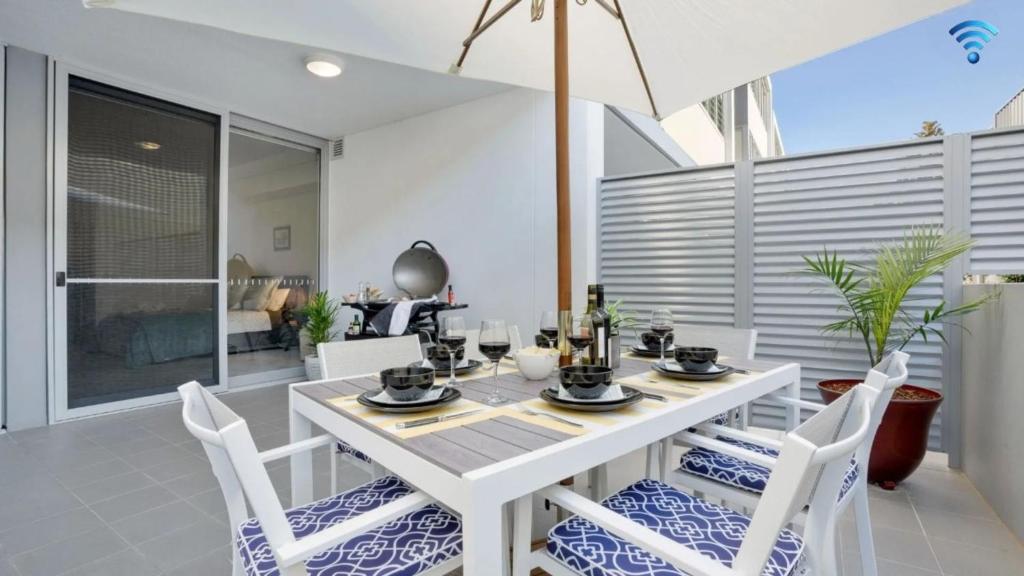 a dining room with a white table and chairs at Riptide on Surf Beach in Kiama