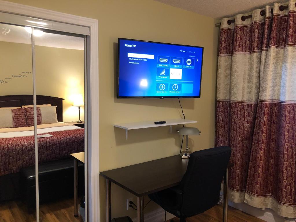 Habitación de hotel con escritorio y TV en la pared en Motel 7 Inn & Suites, en Beresford