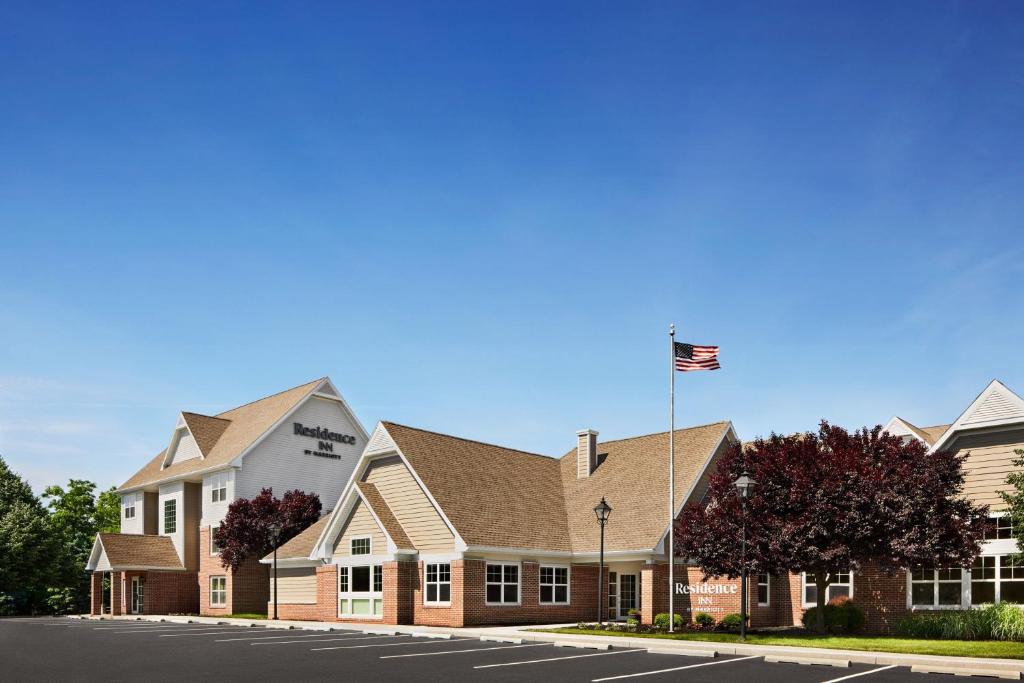 a building with a flag in front of a street at Residence Inn by Marriott Harrisburg Carlisle in Carlisle