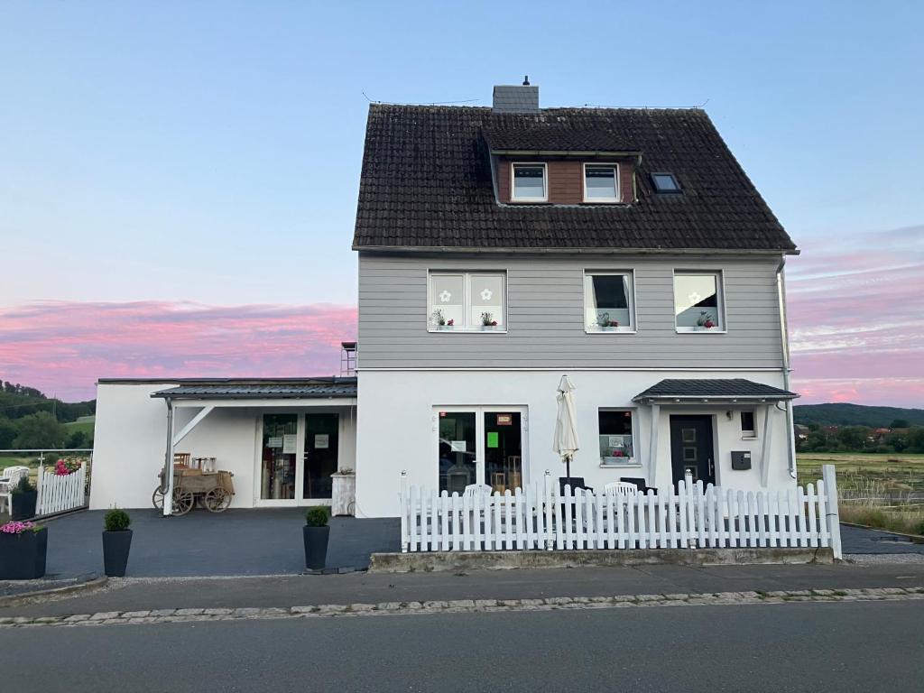 una casa blanca con una valla blanca en Mellys Café & Store, en Einbeck