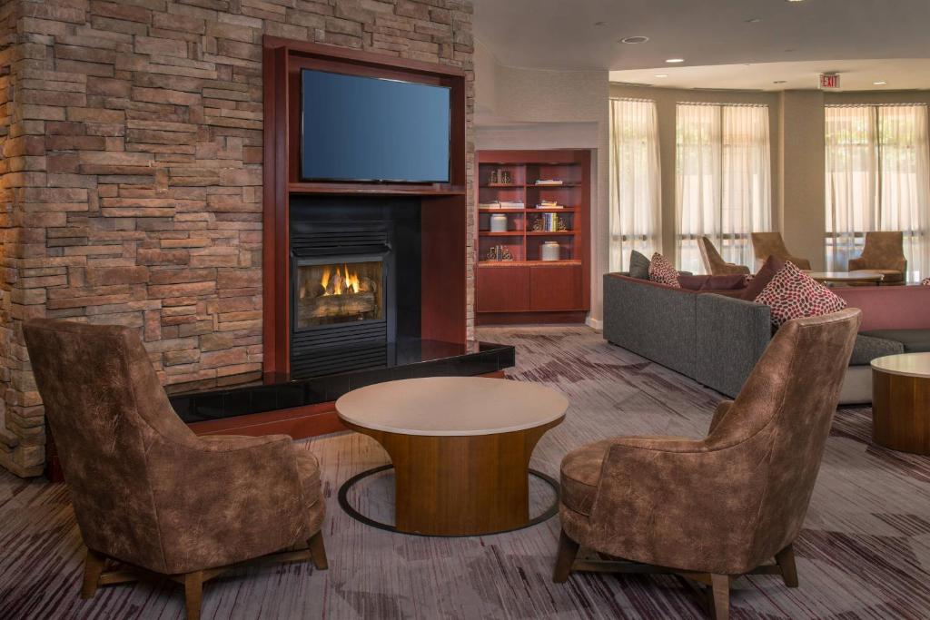 a living room with a fireplace and a tv at Courtyard Fort Meade BWI Business District in Annapolis Junction