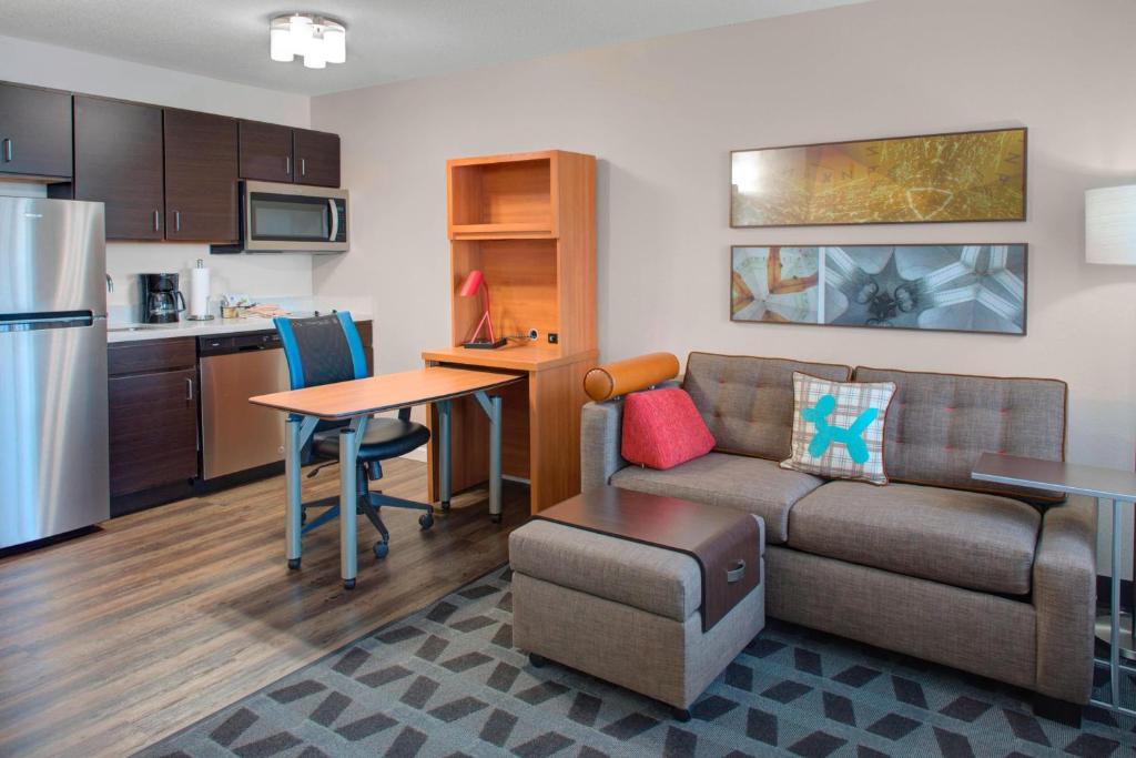a living room with a couch and a table and a kitchen at TownePlace Suites Wichita East in Wichita
