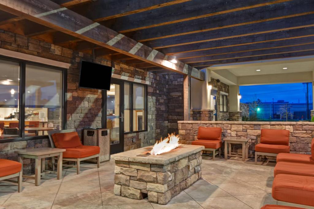 un patio con chimenea, sillas y TV en TownePlace Suites by Marriott Alexandria, en Alexandria