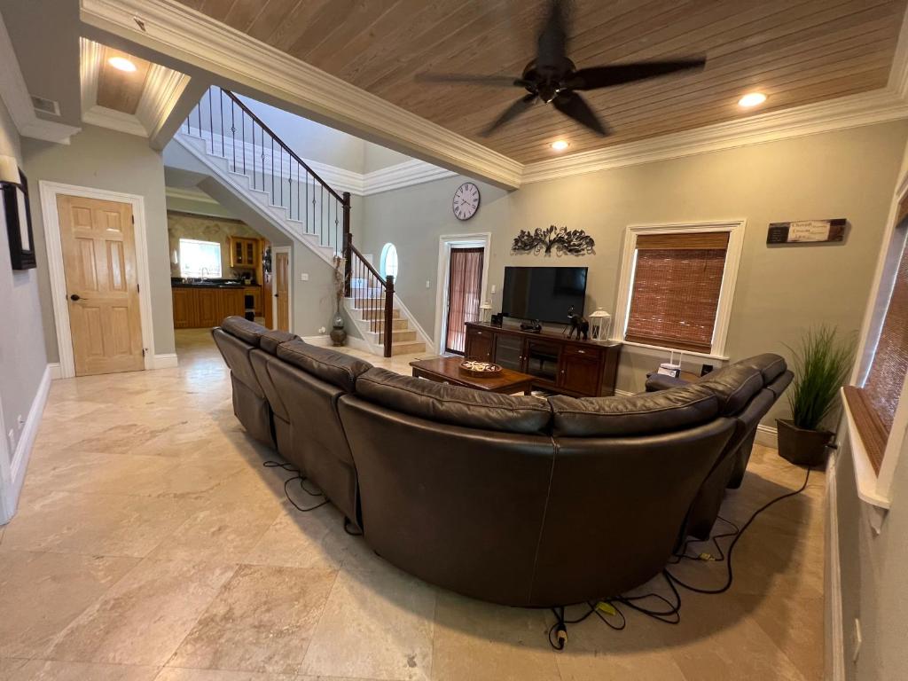 a living room with a couch and a ceiling fan at Hidden Gem Exuma - KING BED master suite and central air in Georgetown