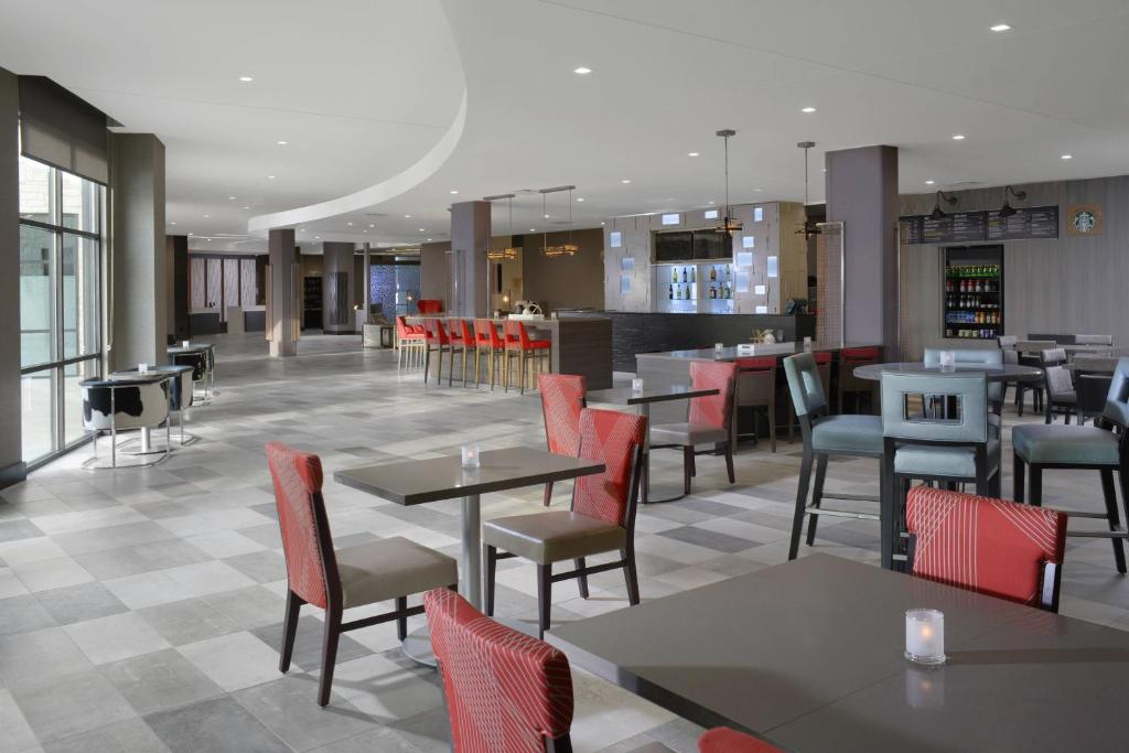 a restaurant with tables and chairs and a bar at Courtyard by Marriott Austin Pflugerville in Pflugerville