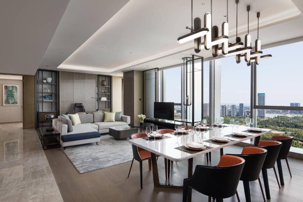 成都市にあるCourtyard by Marriott Chengdu Southのテーブルと椅子のあるダイニングルームとリビングルーム