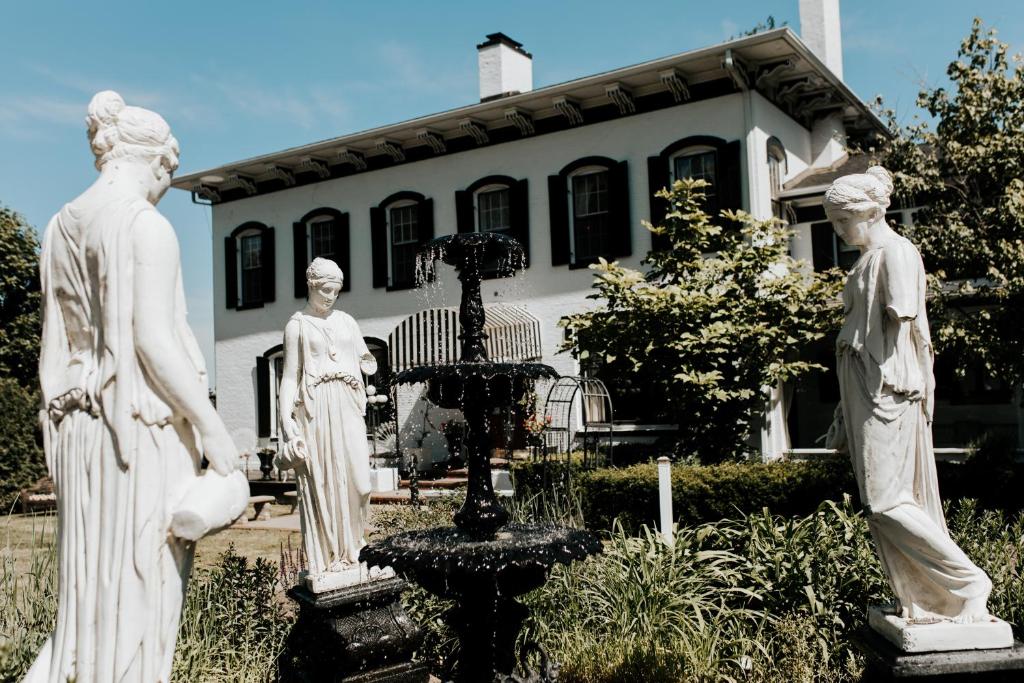 un groupe de statues devant une maison dans l'établissement Maxwell Mansion Hotel, à Lake Geneva