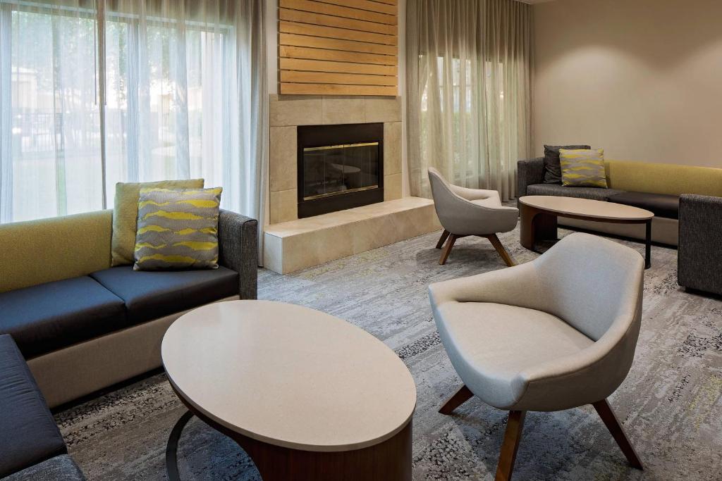 a living room with couches and tables and a fireplace at Courtyard Houston Westchase in Houston