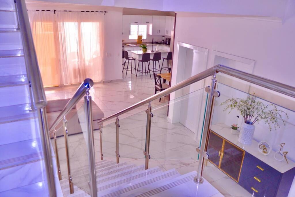 a staircase leading to a kitchen and a living room at Villa Caleta Pool & Heated Jacuzzi in La Romana