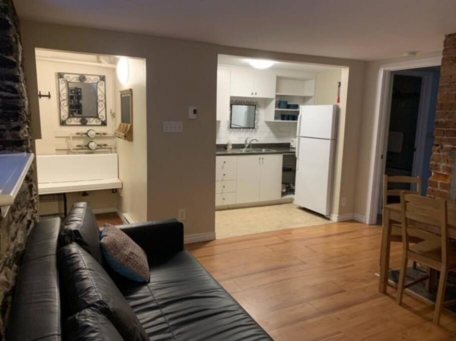 a living room with a couch and a kitchen at Downtown one bedroom/Historic Bauer Terrace in Halifax