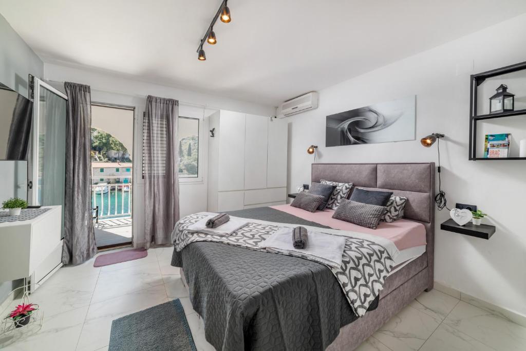 a bedroom with a large bed and a balcony at Amare Apartments in Bobovišća