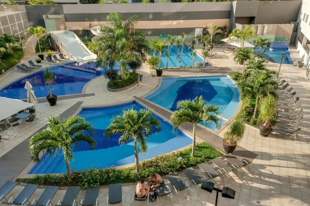 Una vista aérea de una piscina de un complejo turístico con palmeras. en Apto no Veredas do Rio Quente, en Rio Quente