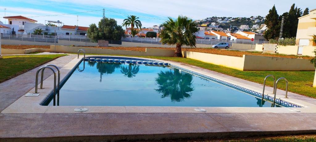 una piscina en un patio con árboles y casas en Chalet independiente con vistas en urbanización privada, en Peñíscola