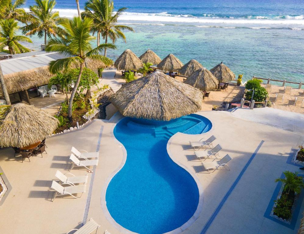 an aerial view of a resort with a swimming pool and the ocean at Club Raro Resort- Adults Only in Rarotonga