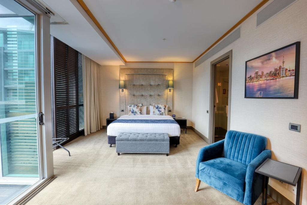 a hotel room with a bed and a blue chair at Marsden Viaduct in Auckland