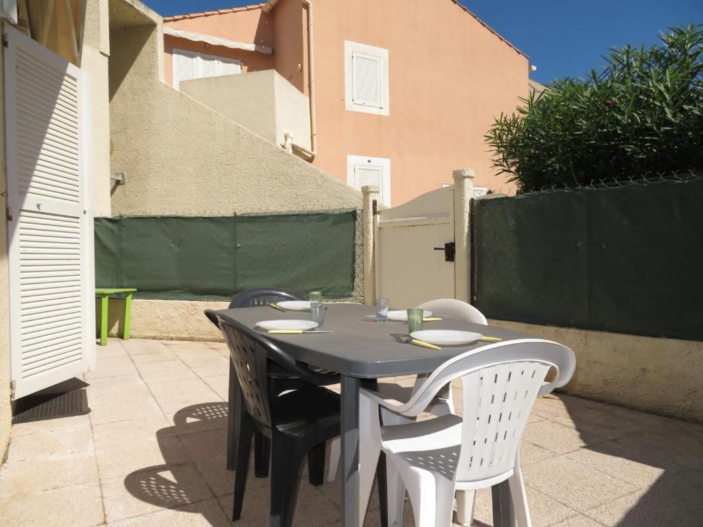 une table et des chaises assises sur une terrasse dans l'établissement Appartement 2 pièces à Sète, 500m de la plage, terrasse, parking, animaux admis - FR-1-338-336, à Sète