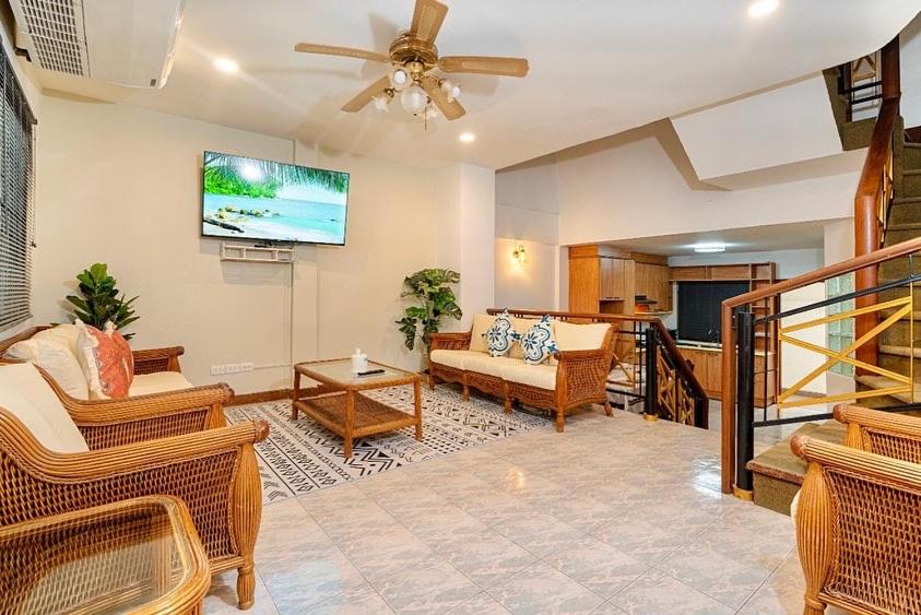 a living room filled with furniture and a ceiling fan at Solene Home Patong in Patong Beach