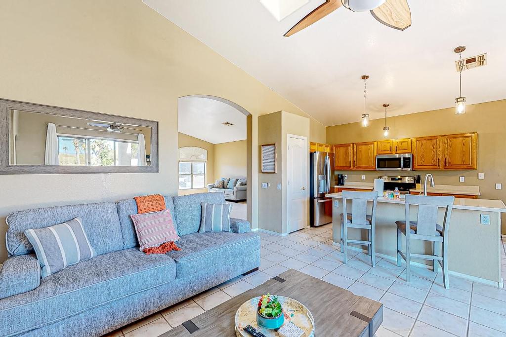 ein Wohnzimmer mit einem blauen Sofa und einer Küche in der Unterkunft Warm Wishes in Phoenix