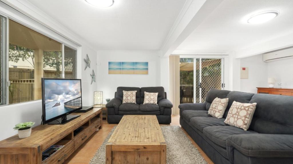 a living room with a couch and a tv at Family Friendly House With Pool & Aircon in Woorim