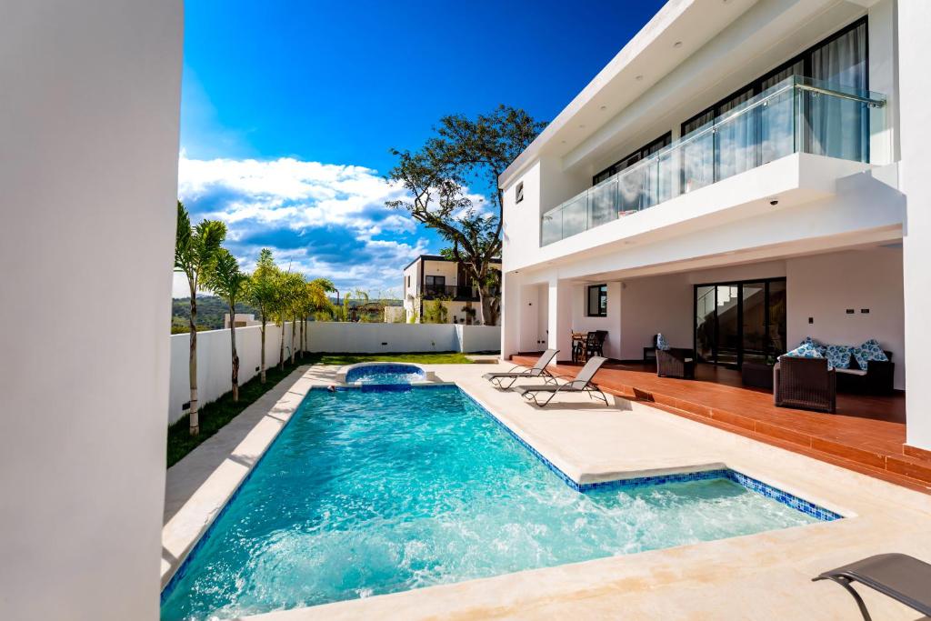Luxury Tropical Paradise Villa 4B Heated Pool في Camú: مسبح في الحديقة الخلفية للمنزل