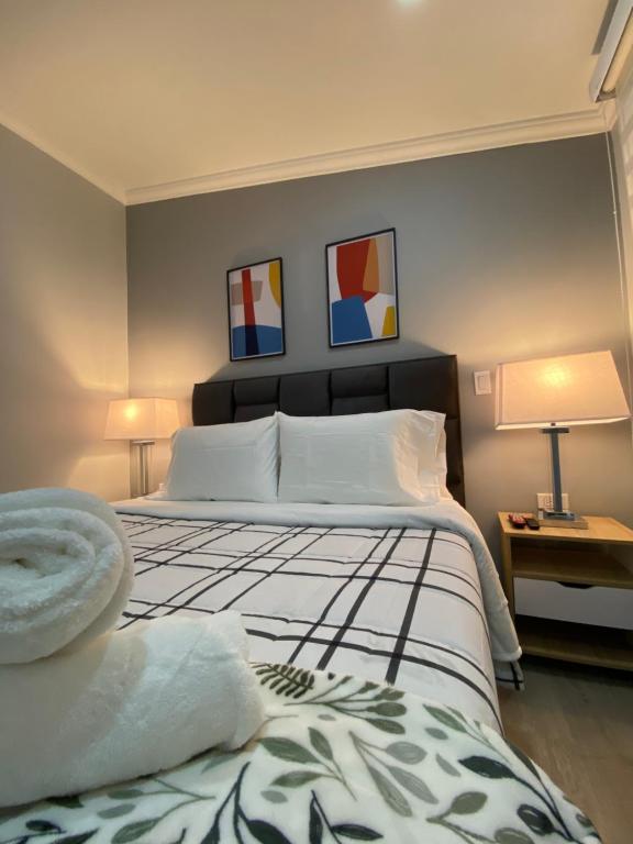 a bedroom with a large bed and two paintings on the wall at Cal Bed & Breakfast in Bogotá