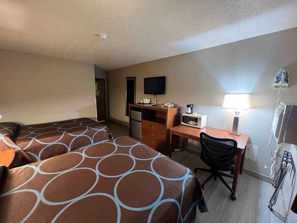 a hotel room with a bed and a desk with a microwave at Raceway inn in Martinsville